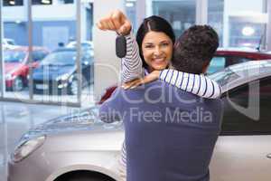 Smiling couple hugging and holding their new key