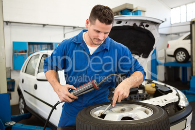 Focused mechanic inflating the tire