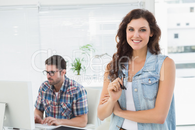 Smiling businesswoman posing with her partner behind her