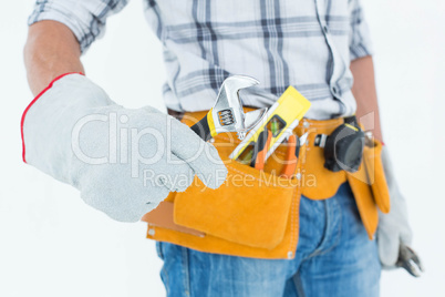 Technician using adjustable wrench against white background