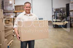 Smiling worker carrying a box