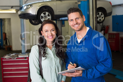 Mechanic smiling at the camera with customer