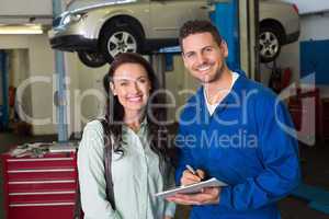 Mechanic smiling at the camera with customer