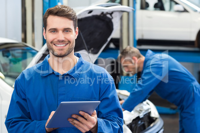 Smiling mechanic using a tablet pc