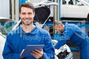 Smiling mechanic using a tablet pc