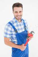 Confident young male repairman holding adjustable pliers