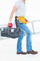 Worker carrying step ladder and tool box
