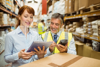 Warehouse managers looking at tablet pc Warehouse managers looking at tablet pc