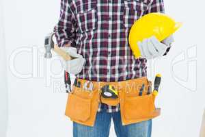 Handyman holding hard hat and hammer