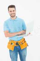 Happy carpenter holding laptop