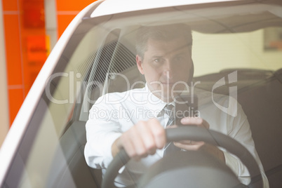 Man sending a text sitting in his car