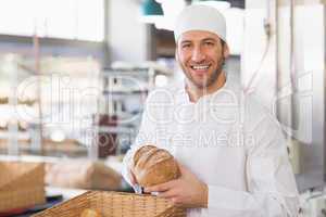 Happy baker with loaf of bread