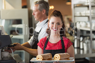 Waitress smiling at the camera showing cakes