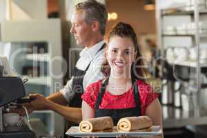 Waitress smiling at the camera showing cakes