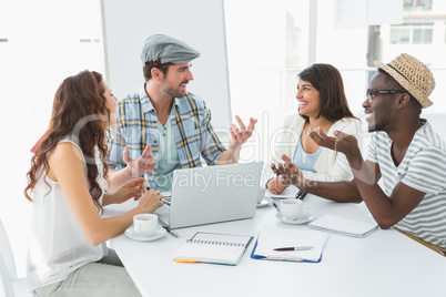 Smiling colleagues interacting and using laptop Smiling colleagues interacting and using laptop
