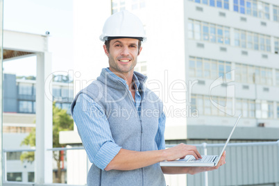 Confident male architect using laptop