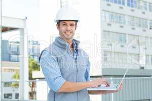 Confident male architect using laptop