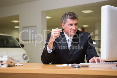 Smiling businessman using his laptop