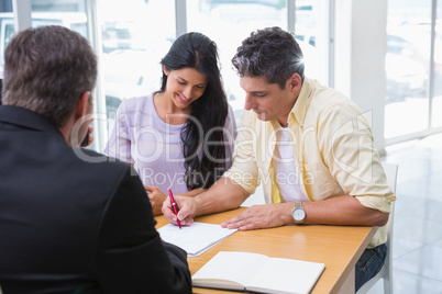 Smiling couple signing a contract