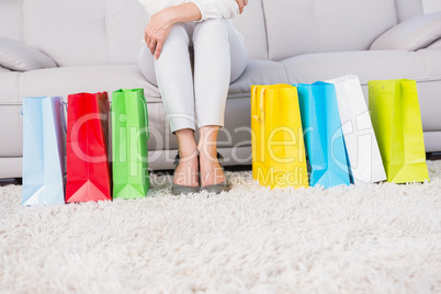 Woman sitting on couch with shopping bags