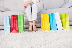 Woman sitting on couch with shopping bags