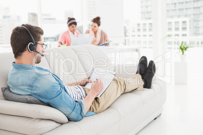 Businessman with headset phoning and taking notes