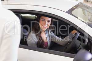 Happy female driver at the wheel sitting in her car