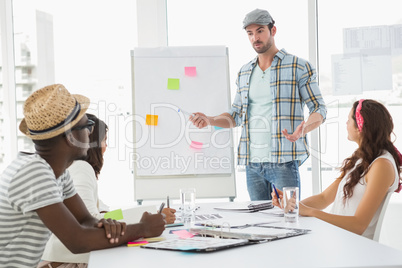 Serious businessman presenting and colleagues listening