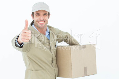 Happy delivery man gesturing thumbs up while carrying box