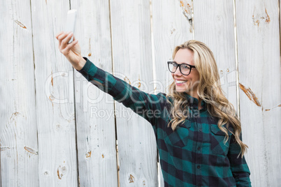 Smiling blonde with glasses taking a selfie