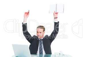 Businessman with arms up holding pencil and notebook