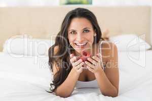 Happy brunette with bowl of strawberries