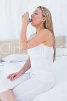 Beauty blonde using asthma inhaler