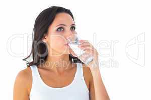 Pretty brunette drinking glass of water