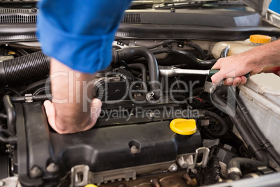 Mechanic examining under hood of car