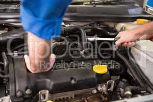 Mechanic examining under hood of car