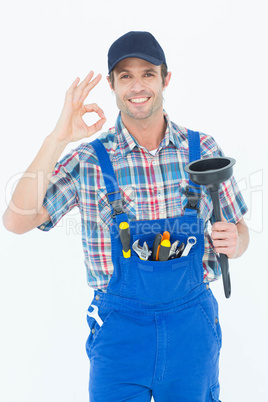 Plumber holding plunger while gesturing OK sign