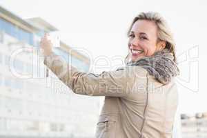 Cheerful blonde with mobile phone and looking at camera