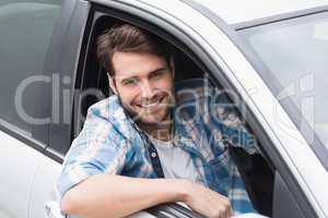 Young man driving and smiling