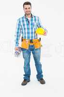 Confident handyman holding hard hat and gloves