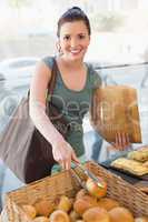 Pretty brunette picking out bread roll