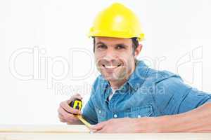 Male carpenter using measue tape