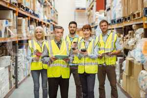 Smiling warehouse team looking at camera