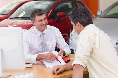 Salesman showing client where to sign the deal