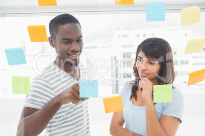 Smiling coworker reading sticky notes