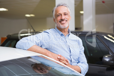 Smiling customer leaning on car