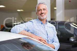 Smiling customer leaning on car