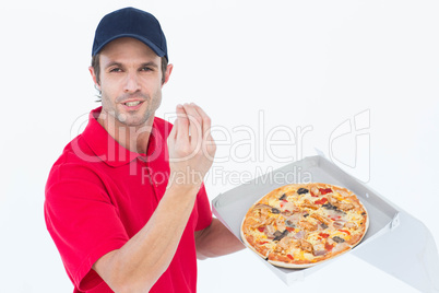 Delivery man gesturing while holding fresh pizza