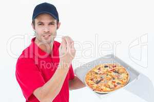 Delivery man gesturing while holding fresh pizza