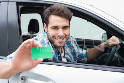 Young man smiling and holding card